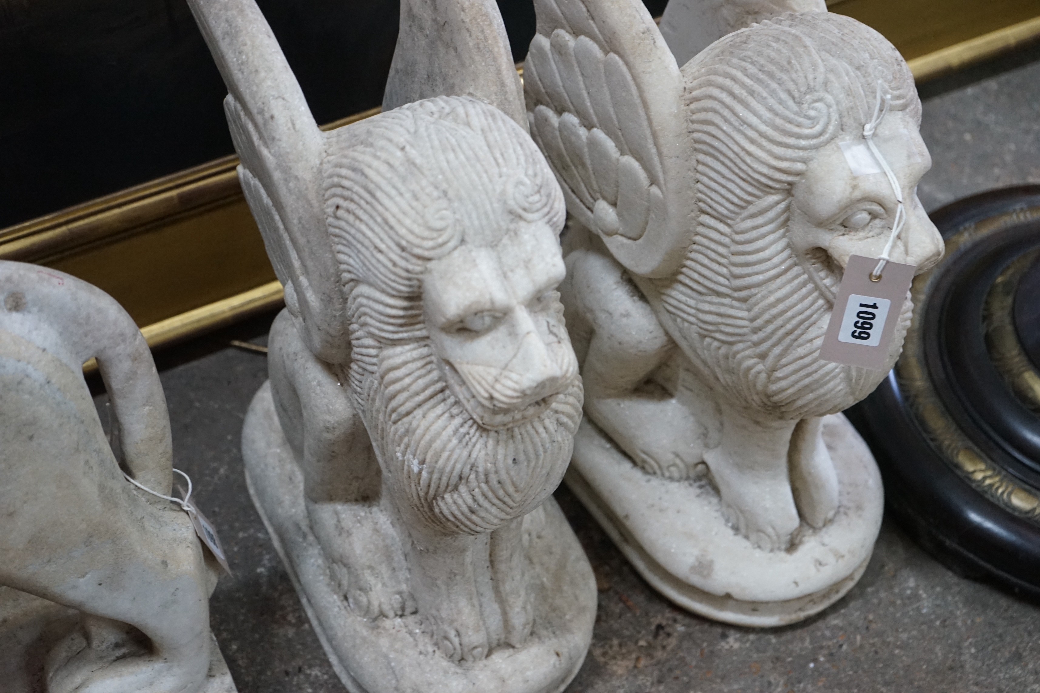 A pair of South East Asian carved stone winged lions, height 40cm